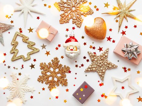 Christmas and New Year background with sparkling fir tree, Santa Claus, heart, snowflakes and star confetti. Holiday decorations on white background with light bulbs.