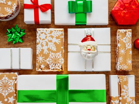 Christmas presents on shabby wooden background. New Year gifts in white and golden paper with bright ribbons.