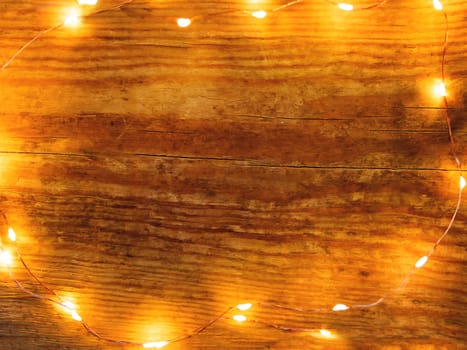 Festive shabby wooden background with light bulbs. Top view, flat lay.