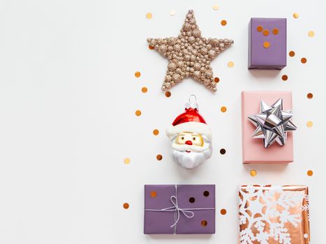 Christmas and New Year background with row of decorations. Santa Claus, golden feathers, presents and stars confetti.