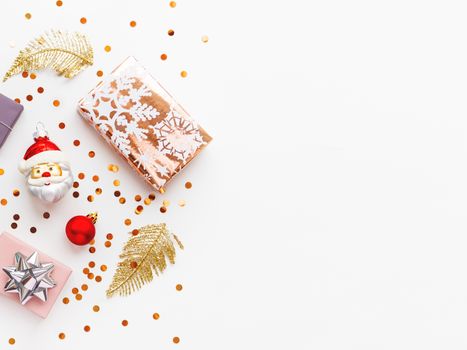 Christmas and New Year 2020 background with decorations. Santa Claus, golden feathers, presents and stars confetti.