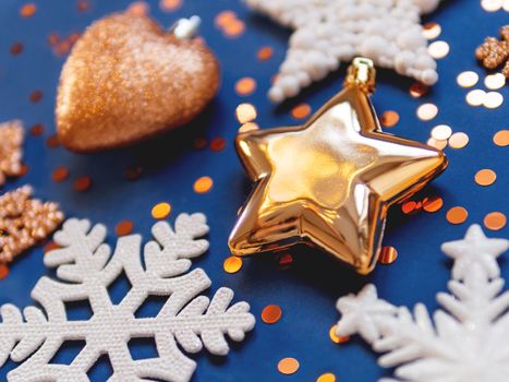 Golden and white decorations for Christmas tree. New Year decorative stars and snowflakes on classic blue background.