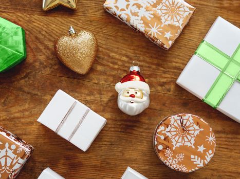 Christmas presents on shabby wooden background. Gifts in white and golden paper with bright ribbons.
