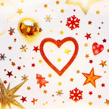Christmas and New Year holiday background with decorations and light bulbs. Red and golden hearts, shiny balls, felt snowflakes and star confetti. Flat lay, top view.
