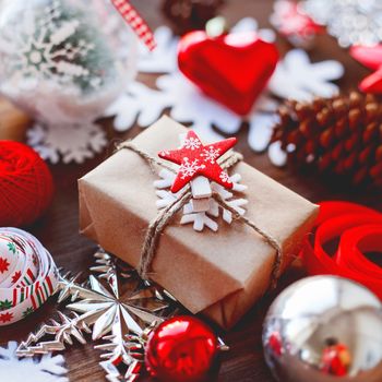 Christmas and New Year background with presents, ribbons, balls and different decorations on wooden background. Gift with red star symbol.