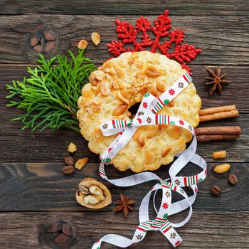 Christmas and New Year background with peanut tart and decorations - snowflake, ribbon, spices. Top view, flat lay.