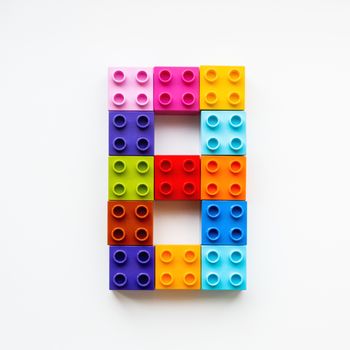 Number Eight made of colorful constructor blocks. Toy bricks lying in order, making number 8. Education process - learning numbers with child using multicolored toy details.