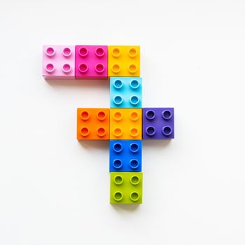 Number Seven made of colorful constructor blocks. Toy bricks lying in order, making number 7. Education process - learning numbers with child using multicolored toy details.