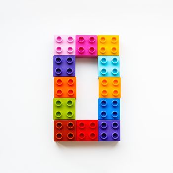 Number Zero made of colorful constructor blocks. Toy bricks lying in order, making number 0. Education process - learning numbers with child using multicolored toy details.