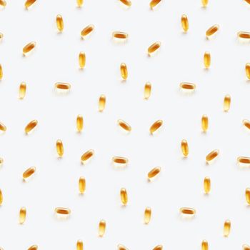 Seamless photo pattern with bright yellow capsules. White background with spilled yellow pills.
