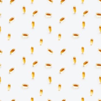 Seamless photo pattern with bright yellow capsules. White background with spilled yellow pills.