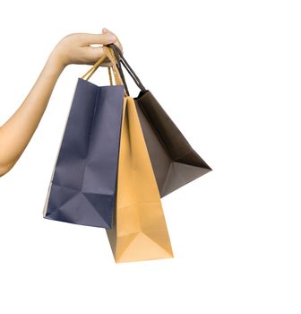 Woman carrying paper shopping bags isolated on white background. Adult woman hand hold three shopping bag with blue and brown color. Customer and shopping bag. Black Friday concept. Consumerism. 