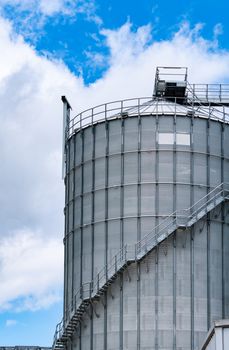 Agricultural silo at feed mill factory. Big tank for store grain in feed manufacturing. Seed stock tower for animal feed production. Commercial feed for livestock, swine and fish industries. 