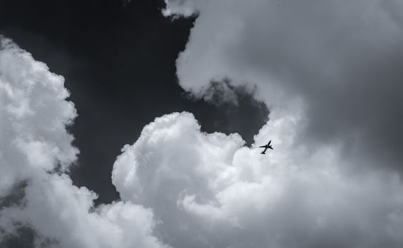 Airplane flying on dark sky and white clouds. Commercial airline with dream destinations concept. Aviation business crisis concept. Failed journey vacation flight. Air transportation. Sad travel.