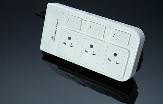 Power strip with three electrical standard socket on black background. White universal plug with overload protection. Fire resistant material for cover. Circuit breaker. Individual switch. Power plug.