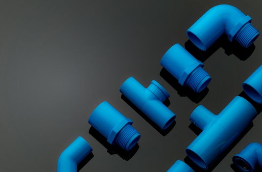 Set of blue PVC pipe fittings isolated on dark background. Blue plastic water pipe. PVC accessories for plumbing. Plumber equipment. Bend and three way connection plastic pipe for water drain sewage.