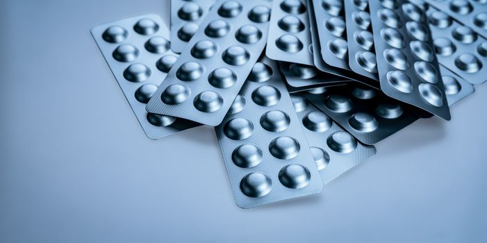 Pile of tablets pill in blister packaging to protect medicine from light. Silver aluminium foil blister pack. Pharmaceutical industry. Pharmacy products. Drug recall and withdrawal from market concept