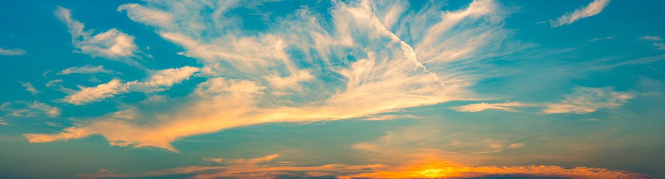 Beautiful blue and golden sky and clouds abstract background. White and golden clouds on sunset sky. Warm weather background. Art picture of sky at sunset. Sunset and fluffy clouds for inspiration.