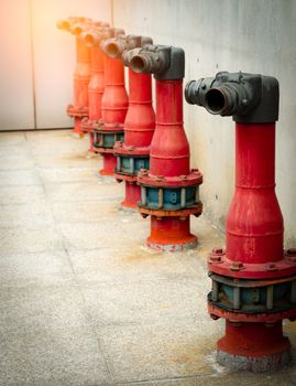 Fire safety pump on cement floor of concrete building. Deluge system of firefighting system. Plumbing fire protection. Red fire pump in front of concrete wall. High pressure fire safety pump.
