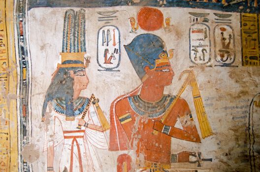 Ancient Egyptian wall painting of the Pharaoh Amenhotep III and his wife Queen Tiy on the inside of a tomb at Luxor, Egypt.  Historic painting, thousands of years old in the Tomb of Amenemonet, priest from the Ramesside Period.