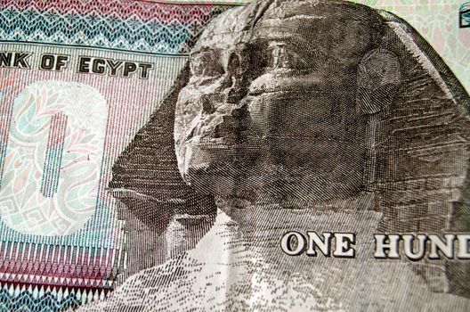 Detail of the one hundred pound banknote from the Egyptian Central bank showing the famous face of the Sphinx of Giza.  Used banknote photographed at an angle