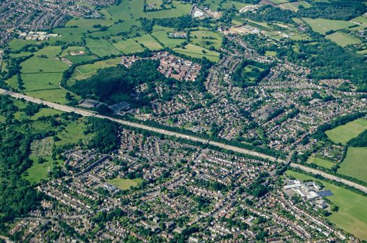 Aerial view of Addlestone in Surrey with the M25 motorway cutting the residential areas in two with Row Town to the upper part of the picture.  In the bottom left corner is Jubilee High School and to the top left is the Animal and Plant Health Agency.