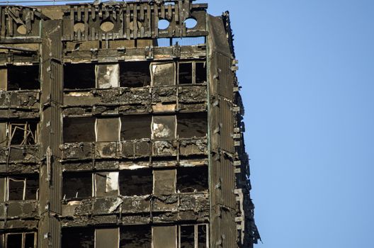 LONDON, UK - JULY 5, 2017: Part of the top floors of the Grenfell Tower block of council flats in which at least 80 people are thought to have been killed following a fire in Kensington, West London.