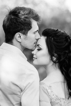 a guy and a girl walk in the spring garden of lilacs before the wedding ceremony