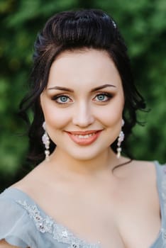 portrait of a brunette girl in a lilac spring garden before the wedding ceremony