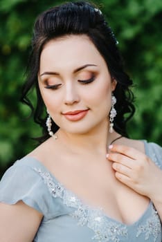 portrait of a brunette girl in a lilac spring garden before the wedding ceremony