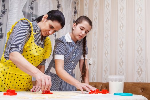 mom and daughter bake homemade cookies in the kitchen. coronavirus quarantine