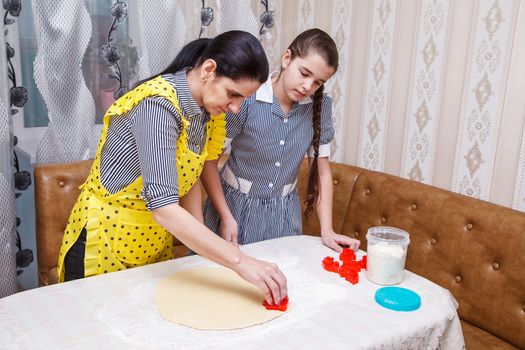 mom and daughter bake homemade cookies in the kitchen. coronavirus quarantine