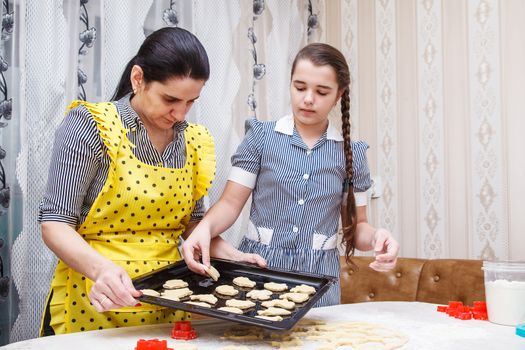 mom and daughter bake homemade cookies in the kitchen. coronavirus quarantine