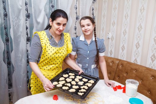 mom and daughter bake homemade cookies in the kitchen. coronavirus quarantine