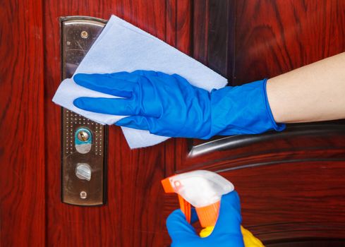 woman disinfects the door handle at home. coronavirus quarantine. hands closeup