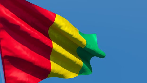 3D rendering of the national flag of Guinea waving in the wind against a blue sky