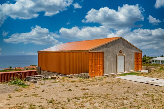 A home made from orange freight containers and concrete