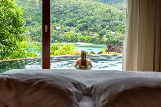 Paradise beach of Seychelles. view of woman's back admiring the sea.