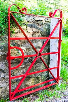 detailed vintage red painted steel gate in rural setting