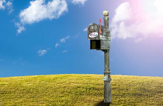 Metal mailbox for rural homes with I Voted sticker as concept for voting by mail or absentee ballot paper on grassy hillside