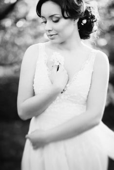 brunette girl in a turquoise dress walking in the spring garden