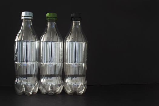 Empty plastic soft drink bottles on a black background