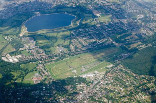 Aerial view of Esher in Surrey with the Sandown Park race course in full view plus the Island Barn Reservoir and the River Mole.  Sunny summer day.
