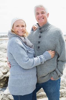 Romantic senior couple standing together on a rocky beach