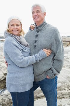 Romantic senior couple standing together on a rocky beach
