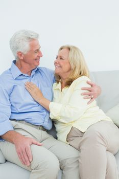 Happy romantic senior couple sitting on sofa in a house