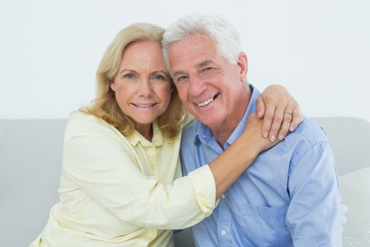 Portrait of a romantic relaxed senior couple sitting on sofa in a house