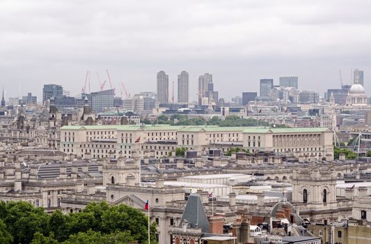 View across the rooftops of Whitehall with the green copper rooftop of the Ministry of Defence dominating the scene.  Barbican tower blocks , St Paul's Cathedral and the City of London in the distance.