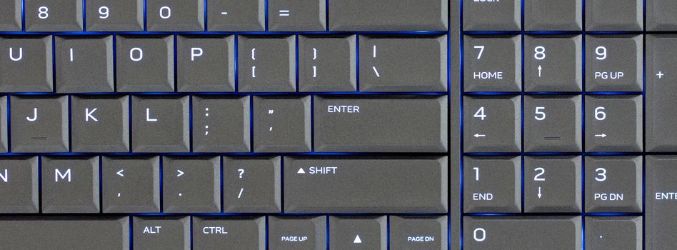 Close up led backlit computer laptop keyboard, blue