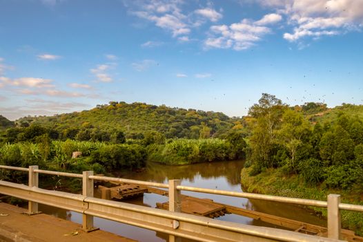 view of a river and a tropical landscape along the road at the exit of Tyka near Nairobi in Kenya